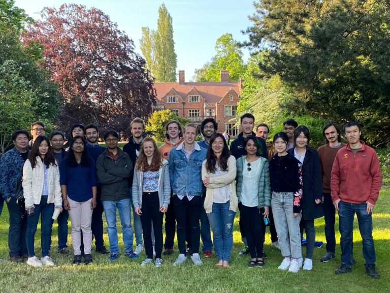 Members of the Rao Group standing together on a lawn, 2021